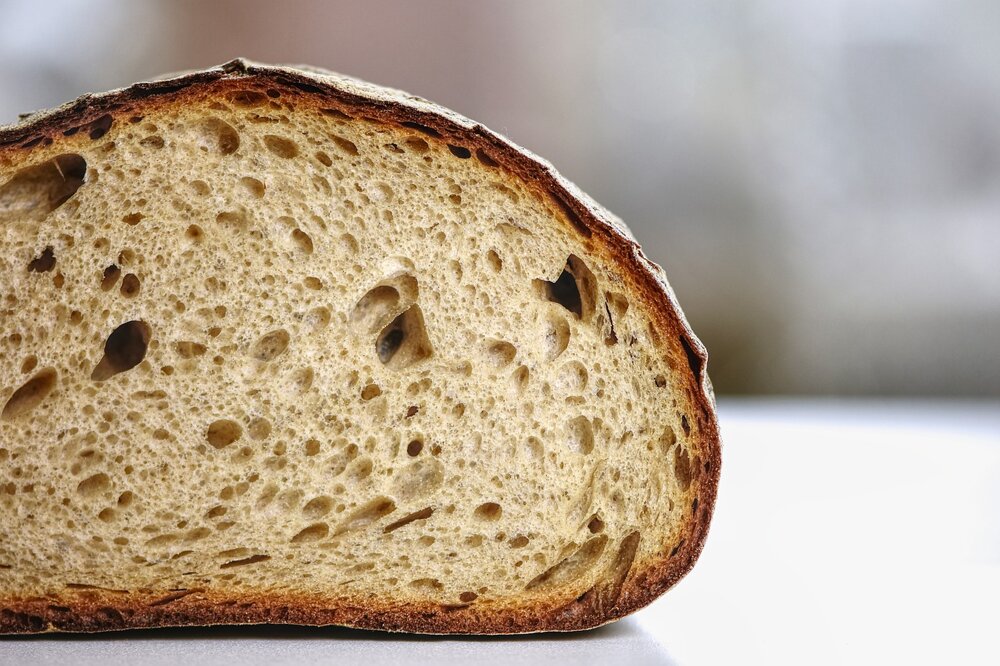 Mezza pagnotta di pane sul fondo bianco