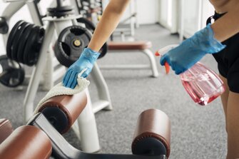 woman-with-gloves-gym-disinfecting-equipment.jpeg woman-with-gloves-gym-disinfecting-equipment.jpeg
