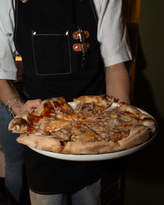 Pizza tonda ad alta idratazione della pizzeria Olltre a San Zeno Verona con ingredienti italiani