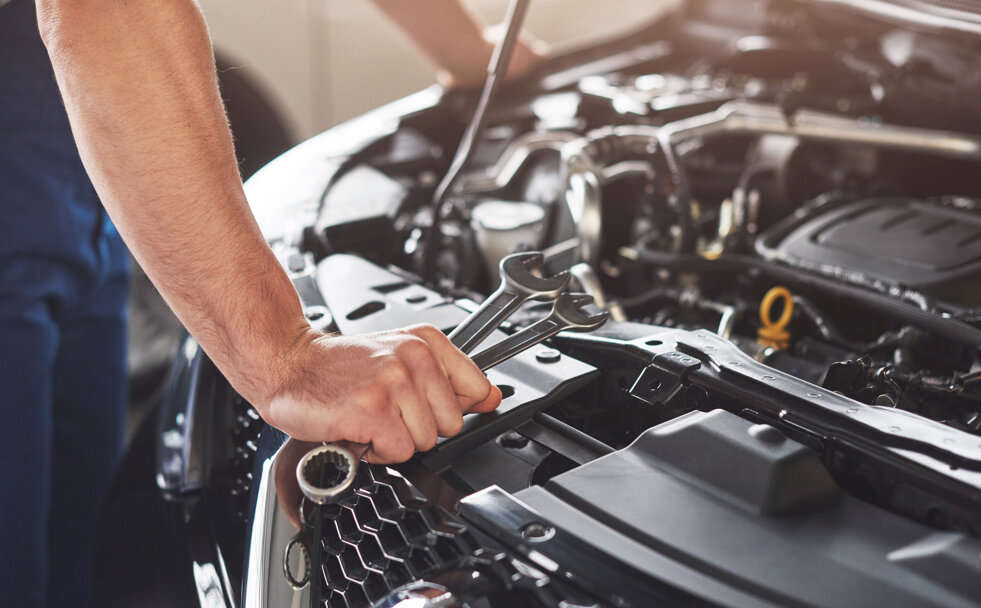 muscular-car-service-worker-repairing-vehicle.jpeg