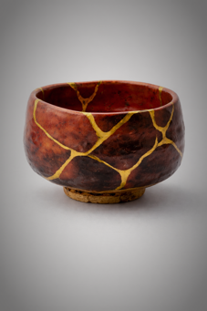Tazza rossa con venurare dorate in stile kinttsugi