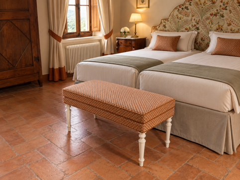 camera da letto classica con letti gemelli e panca