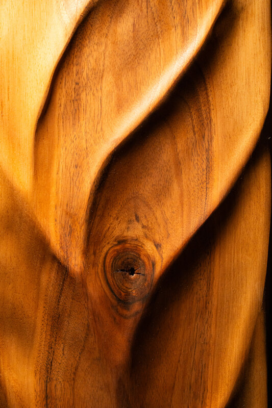 Dettaglio di opera scultorea in legno con superfici fluide e lavorazione artigianale