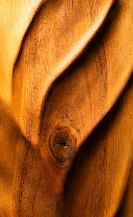 Dettaglio di opera scultorea in legno con superfici fluide e lavorazione artigianale