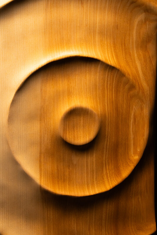 Dettaglio di opera scultorea in legno con superfici fluide e lavorazione artigianale