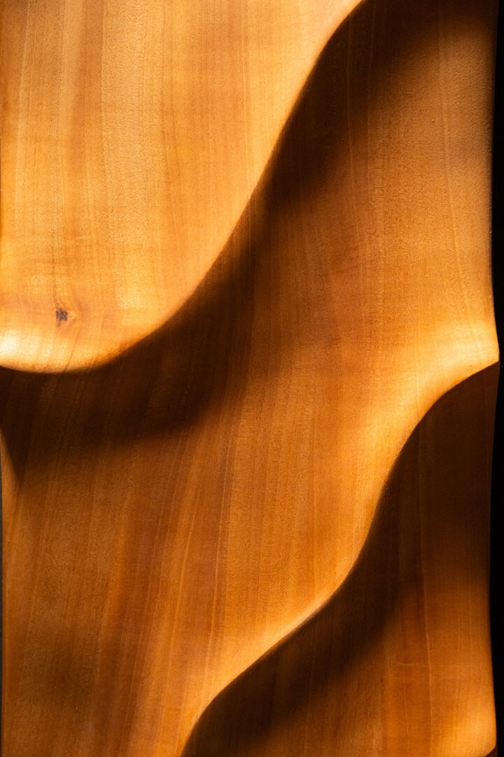 Dettaglio di opera scultorea in legno massello con superfici fluide e organiche realizzata a mano Dettaglio di opera scultorea in legno massello con superfici fluide e organiche realizzata a mano