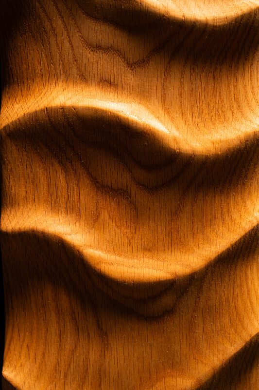 Dettaglio di opera scultorea in legno massello con superfici fluide e organiche realizzata a mano
