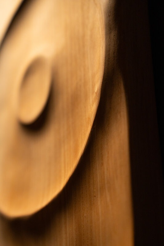 Dettaglio di opera scultorea in legno con superfici fluide e lavorazione artigianale