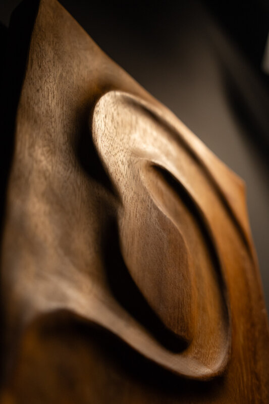 Dettaglio di opera scultorea in legno con superfici fluide e lavorazione artigianale