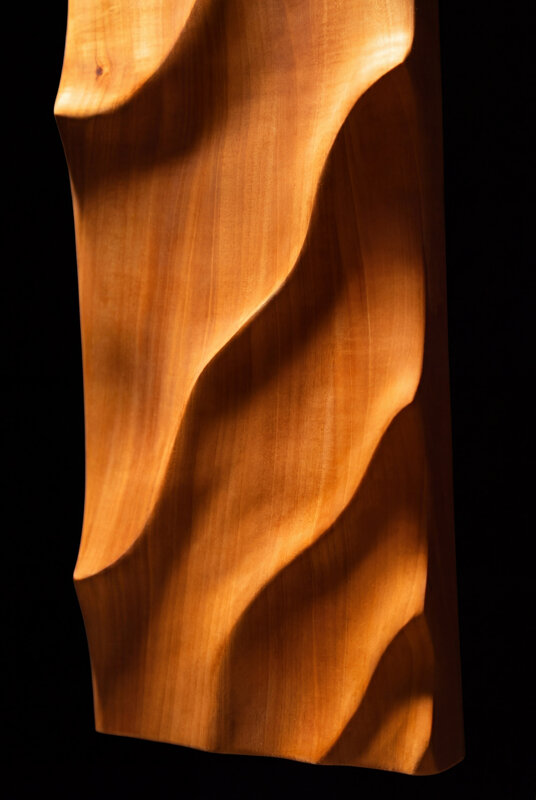 Dettaglio di opera scultorea in legno con superfici fluide e lavorazione artigianale