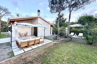 Giardino con prato, alberi e sentiero che conduce alla villa.