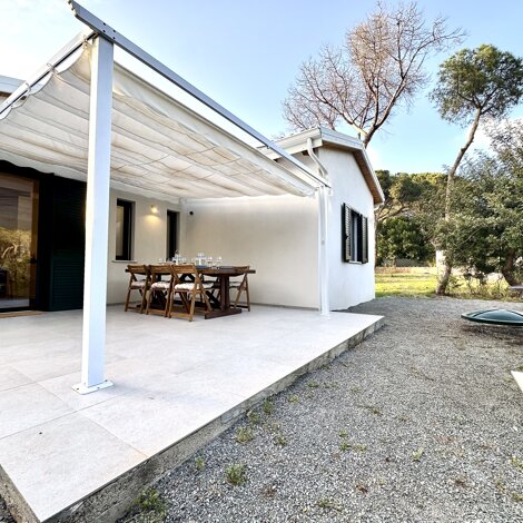 Patio esterno con tavolo da pranzo e barbecue.