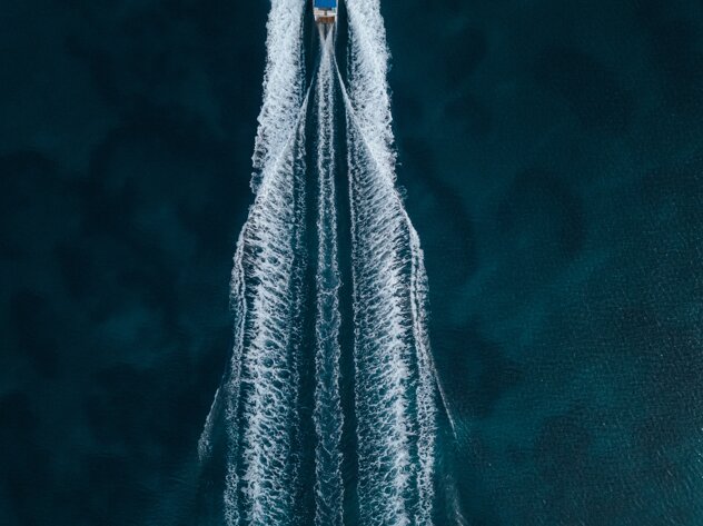 aerial-overhead-shot-motorboat-sailing-forward-middle-ocean.jpeg