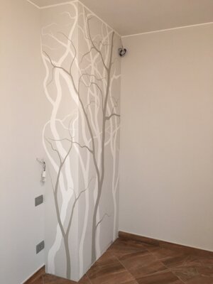 Tinteggiatura decorativa con alberi stilizzati tono su tono su angolo di parete