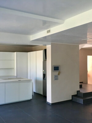 Open space cucina-soggiorno moderno con pareti tinteggiate in beige chiaro, soffitto lucido Open space cucina-soggiorno moderno con pareti tinteggiate in beige chiaro, soffitto lucido