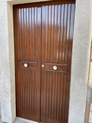 Portoncino in legno a doghe verticali restaurato con verniciatura protettiva lucida color noce