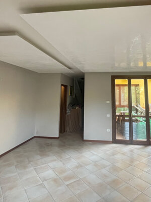 Tinteggiatura soggiorno con pareti grigio caldo uniforme e controsoffitto bianco lucido a livelli