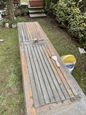 In questa foto il portoncino in legno appare molto usurato: vecchia vernice scrostata