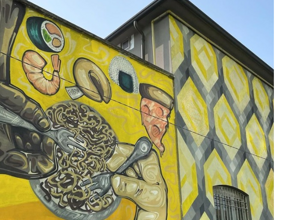 Yellow street art mural in the Bovisa neighbourhood of Milan
