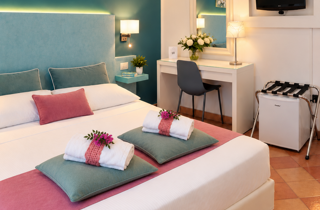 Letto matrimoniale con cuscini decorativi e arredi coordinati nella camera del B&B La Magnolia nel Cilento.