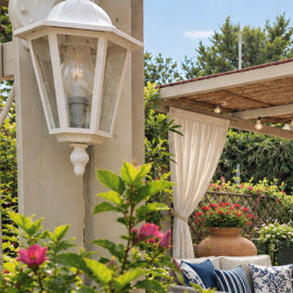 Scorcio del giardino del B&B La Magnolia a San Marco di Castellabate, con piante ornamentali, fiori colorati e tende bianche.