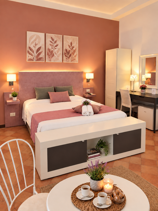 Camera matrimoniale e familiare del B&B La Magnolia a San Marco di Castellabate, con letto matrimoniale, divano letto e arredi rosa cipria.