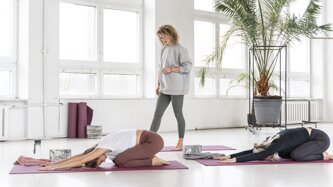 full-shot-teacher-watching-women-stretching.jpeg