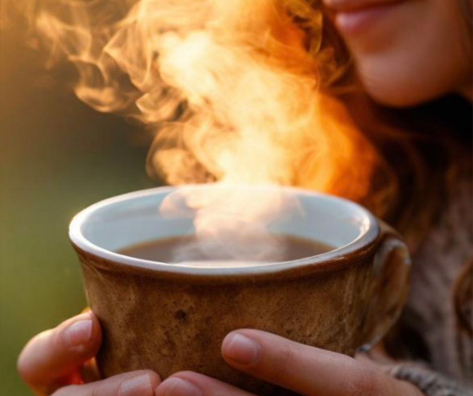 tazza calda tra le mani con vapore al tramonto simbolo di desiderio che torna con calma stile hygge
