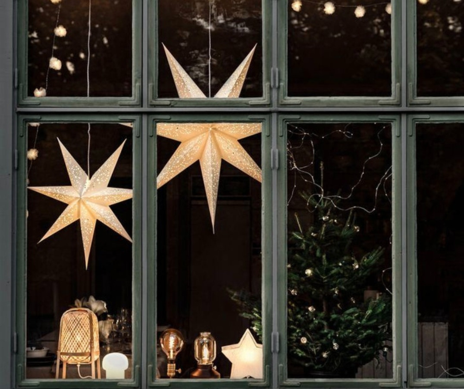 finestre danesi con stelle luminose e luci calde che annunciano l’arrivo di dicembre in stile hygge
