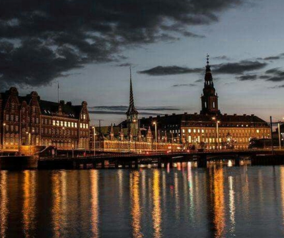 Candele e luce hygge: la magia che nasce dal buio veduta serale di Copenaghen con luci riflesse sull’acqua e atmosfera hygge al tramonto