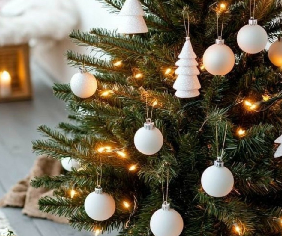 Albero di Natale decorato con palline bianche e luci calde in stile Hygge