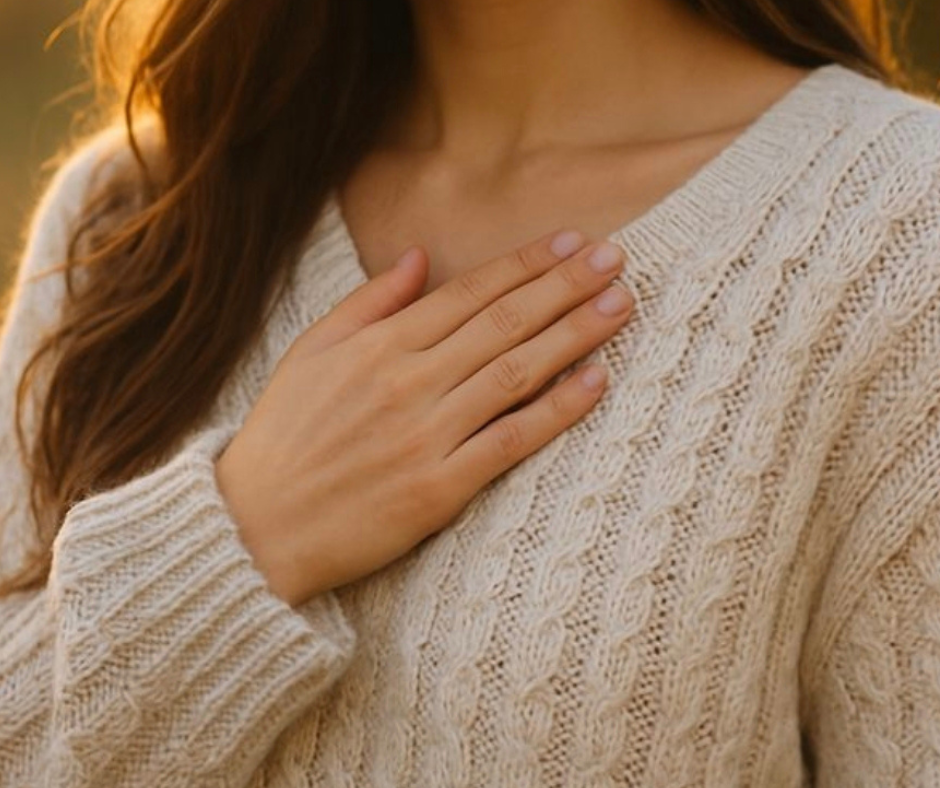 Se senti parlare di cortisolo, spesso fa paura Donna con mano sul petto in gesto di ascolto del corpo, simbolo di regolazione del cortisolo e sicurezza del sistema nervoso in stile hygge