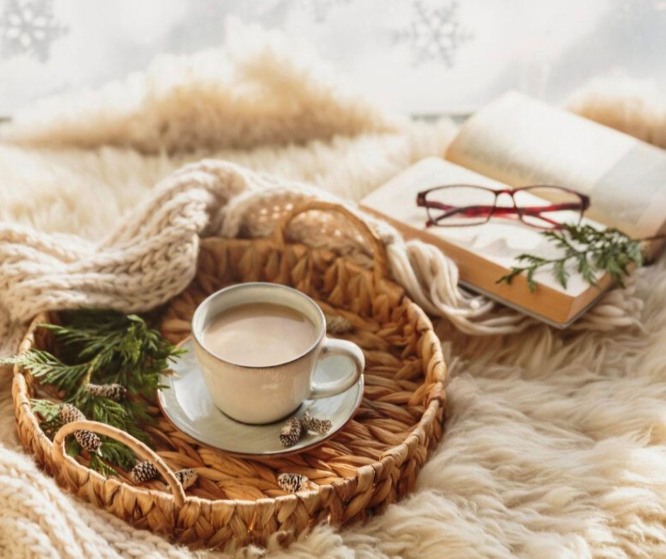 È ora di cambiare qualcosa (anche se non sai ancora cosa) Tazza calda su vassoio intrecciato con libro e coperta, simbolo di presenza e pausa consapevole nella vita quotidiana