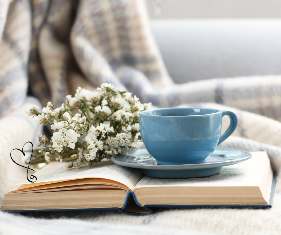 hygge, ambiente rilassante, colori pastelli, libro, tazza di tè, fiori bianchi