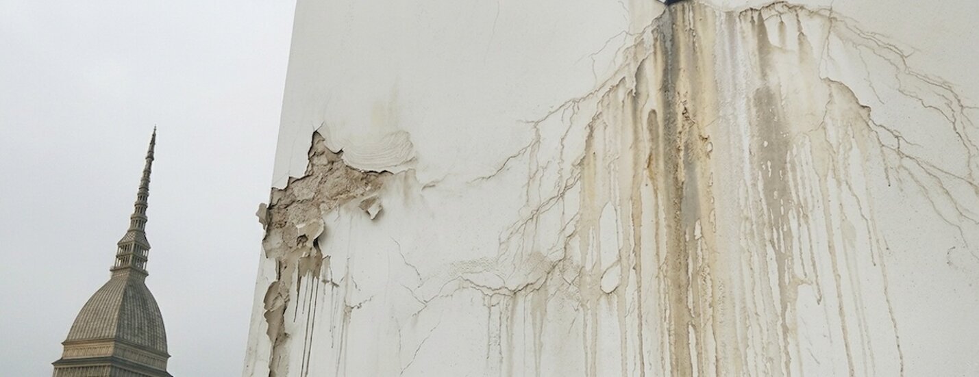 Fotografia si un muro che presenta danni da infiltrazione di acqua.