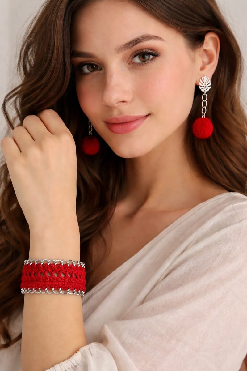Set gioielli artigianli con bracciale rosso all'uncinetto e orecchini pendenti con pompon rossi fatti a mano.