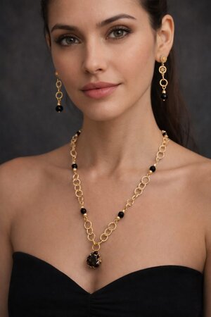 Collana artigianale con perle nere anelli dorati e pendente ossidiana. Fatti a mano